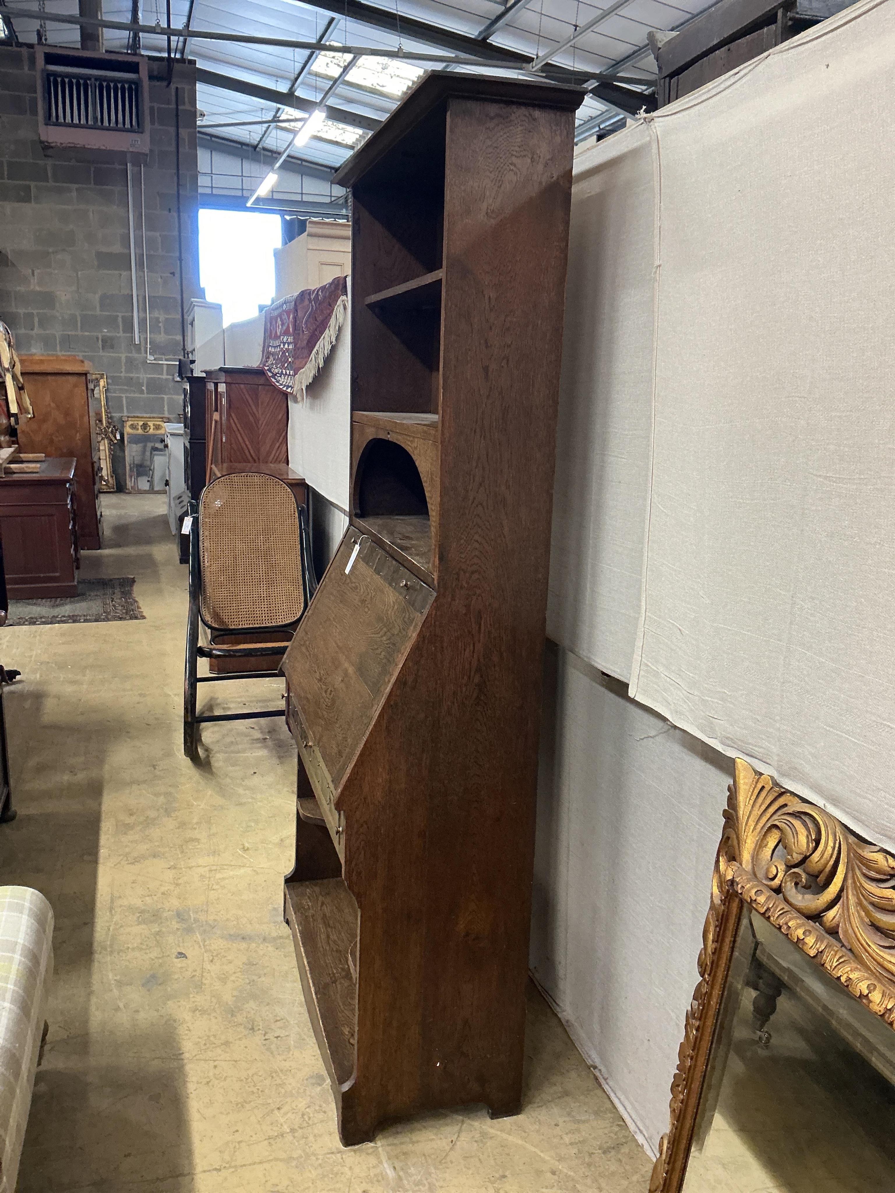 An Arts and Crafts brass mounted oak bureau bookcase, width 84cm, depth 38cm, height 185cm. Condition - fair
